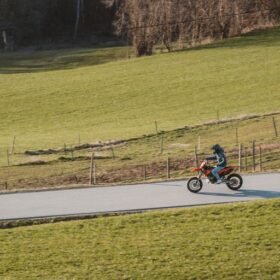 A motorcyclist is riding down a rural road.
