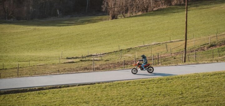 A motorcyclist is riding down a rural road.