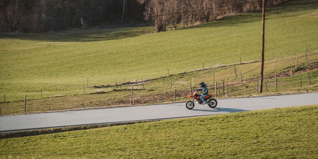 A motorcyclist is riding down a rural road.